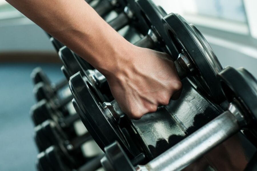 Hand reaching for a weight on a rack of weights