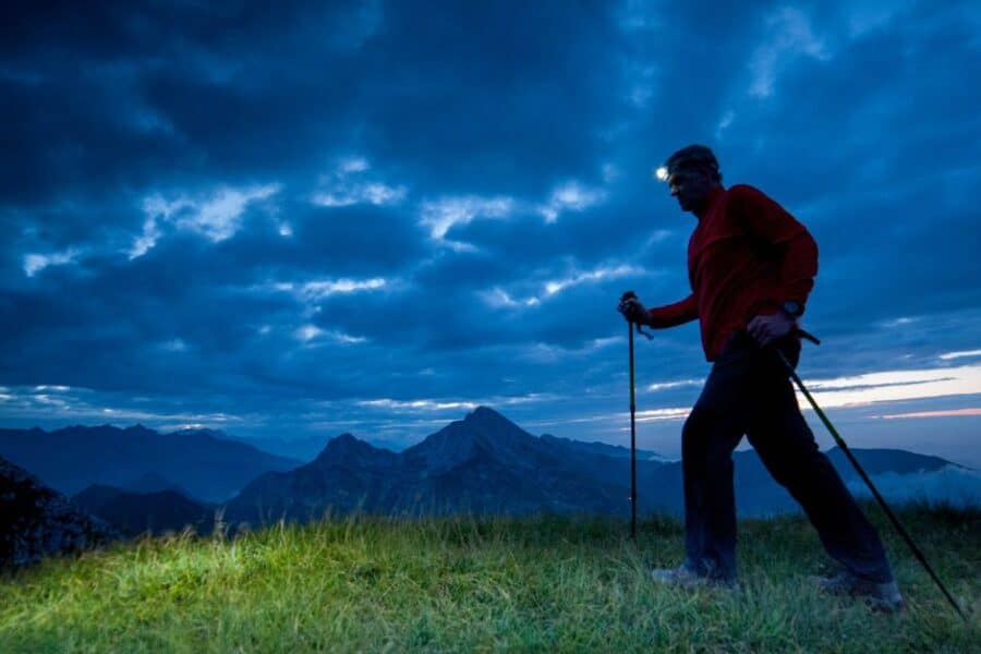 Man hiking at night in nature with headlamp on